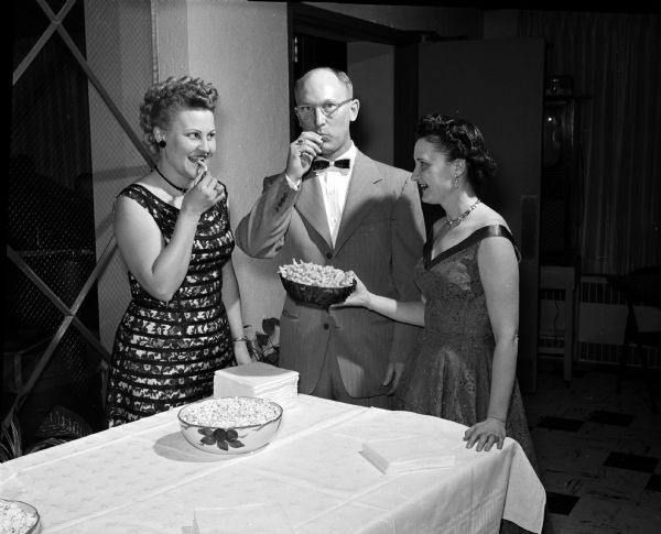 Residents of Westmorland attend a mid-winter dance at the Nakoma Country Club at 4145 Country Club Road. Enjoying snacks are Mrs. Don (Ruth) Fisher, 520 South Owen Drive, chairman of the party; Mr. Fisher and Mrs. R.B. (Luella) Barsness, 3902 St. Clair Street, president of the Westmorland Association.