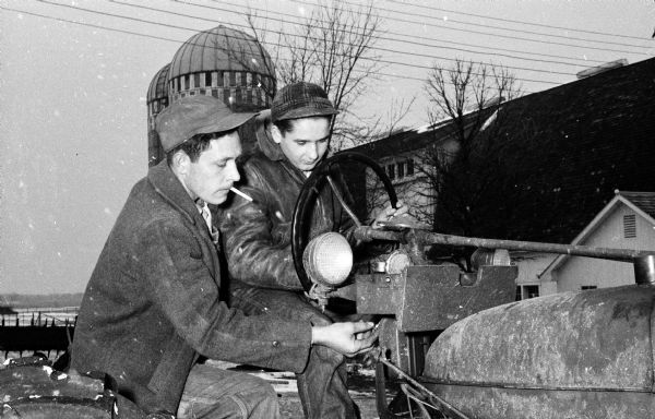 Lasslo (Larry) Csukardy, a Hungarian refugee, receives instruction about operating a tractor from his "American father" Don Andree.