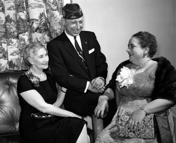The president of the national auxiliary of the Veterans of Foreign Wars, Mrs. Pat Kveton of Dallas, Texas, was a guest of honor at a banquet at the Park Hotel. She is greeted by the Wisconsin auxiliary president, Mrs. Ray Mecklenburg of Milwaukee (left) and John Janto of Milwaukee, VFW commander.