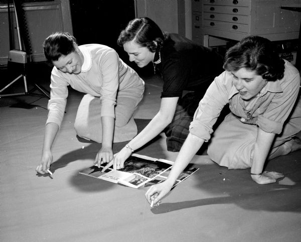 Gail Mosely (left) of 3209 Lake Mendota Drive, Judy Hawkes, 304 Lakewood Blvd., and Gill Wolff, 3006 Harvard Drive work on a poster for the formal dance at WIsconsin High School, sponsored by the high school service club, Philomathia.