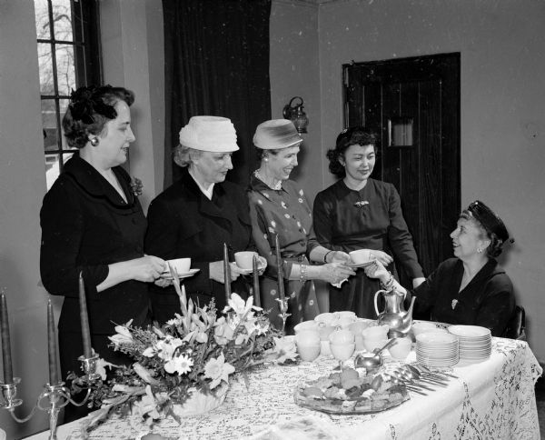 Songs from foreign lands were presented at a benefit musicale at the St. Francis House, 1001 University Avenue. The event was sponsored by  Episcopalians for the benefit of the Episcopalian Student center. Guests served at the tea table include, left to right: Dorothy Dunn, Gertrude Rellahan, Mary Lou Adams, Mrs. Reid Allen, and Elizabeth Morgan.