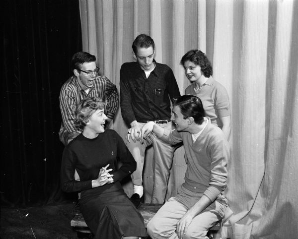 An informal shot of five of "Naughty Marietta" operetta's leading characters. Shown seated are Joan Herreid (Lizette) and Dick Togstad (Lt. Gov. Grandet). Standing are Andy Herriott (the villain, Etienne), Jeffrey Dean (Capt. Dick), and Emmy Curless (the star, Marietta).
