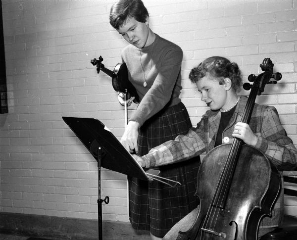 The Central High orchestra accompanied the singers for the presentation of the operetta, "The Waltz Dream."  Rehearsing with their instruments are Mary Vallem, 403 Washburn Place, violinist, and Mary Gerrow, 821 Jenifer Street, cellist.