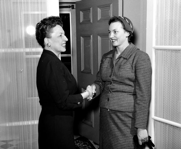 Wisconsin's governor's wife Helen Thomson, (left) greets Mrs. Ruth Kearl of Madison at a tea in the executive mansion for the Wisconsin League of Women Voters after a session at the Wisconsin State Capitol for the league's legislative school.