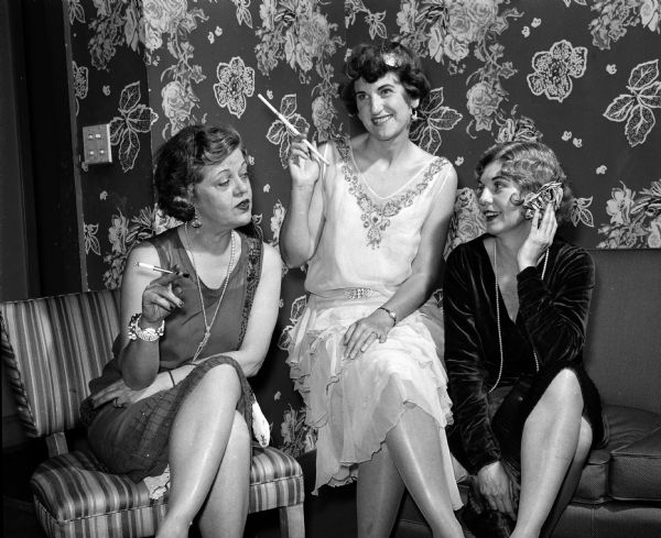 "Blase beyond words were these three Shorewood women who came to the party in the abbreviated, waist-less, low-necked frocks characteristic of the 1920s." Enjoying their elongated cigarette holders are Elizabeth Neal, Viola Field, and Marion Flinn.