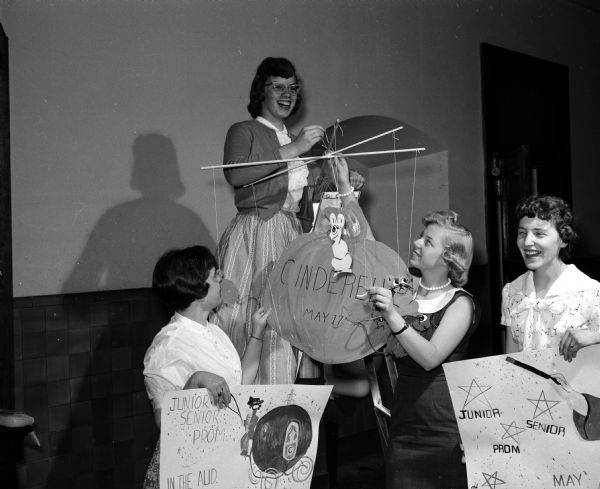 "Cinderella" is the theme of the Edgewood High School Junior-Senior Prom.  Members of the poster and publicity committee: Kathy Connell, Darlene DeBower, Rosemary Keefe and Janie Wartner, chairman, are shown as they prepare a mobile.