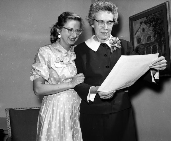 Marie Endres, right, is reading a citation presented to her by Helen Quade Kane, Beaver Dam.  Miss Endres is being honored by the National Federation of Music Clubs for her promotion of interest in string music. She founded and conducts the Madison Spring Sinfonia; is concertmaster and assistant conductor of the Madiso Civic Symphony orchestra and teaches violin at the Wisconsin School of Music and Milton College.
