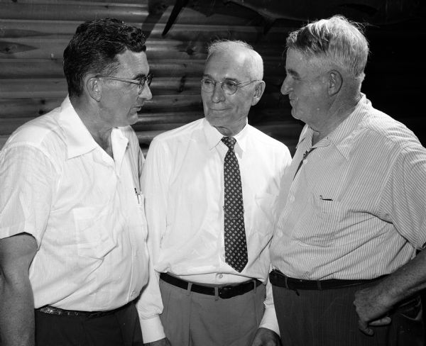 Three men visit at a Graber dinner.