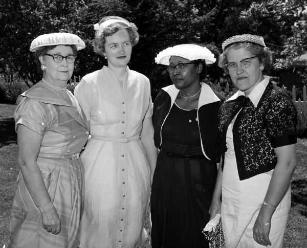 Women attending the Madison Council of Church Women's afternoon tea. Standing left to right are Catherine Handford, Ruth Stream, Maggie Davis, and Mrs. Laurence Malberg.