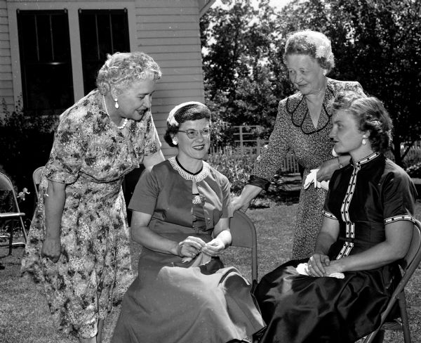 Four women gather on the lawn to chat during the Madison Council of Church Women's afternoon tea. They include (left to right) Bessie Schaefer, Mrs. Richard Summers (Middleton), Clara Erickson, and Mrs. Owen Akers (Monona).
