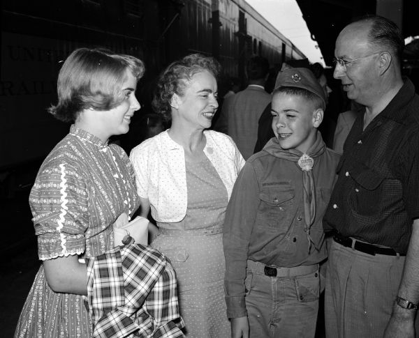Reedsburg Boy Scout Andy Nichols prepares to leave for a national Jamboree at Valley Force, Pennsylvania. He stands with his family at Madison's Milwaukee railway station. They include, from left: Ann Nichols, Mrs. M.E. Nichols, Andy Nichols, and Mr. M.E. Nichols.