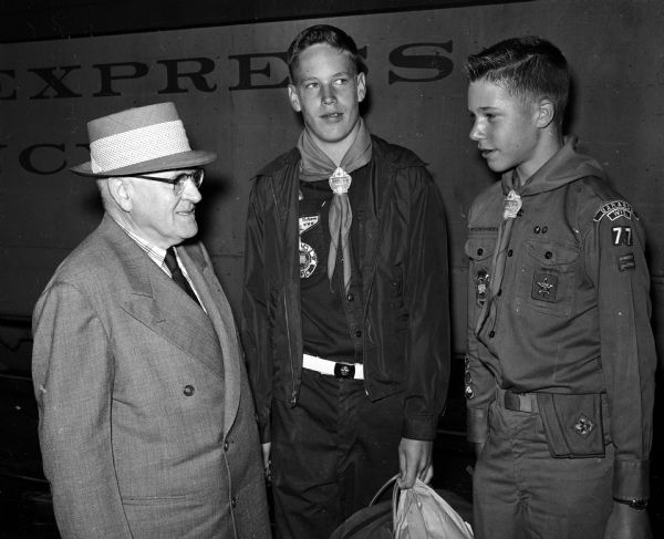 George Morris says farewell to Boy Scouts Fred Rikkers of Madison (center), and David Rambow of Baraboo (right) at the railway station as they leave for the Boy Scout Jamboree at Valley Forge, Pennsylvania.