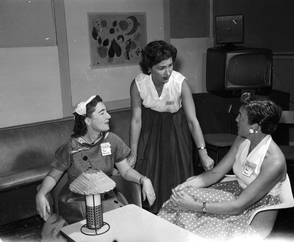 Fay Blalock and Mrs. Elmer Vorse are greeted by Marie Pease at the Truax Field Officers Wives Club. Pease is wife of the base commander at Truax Field.