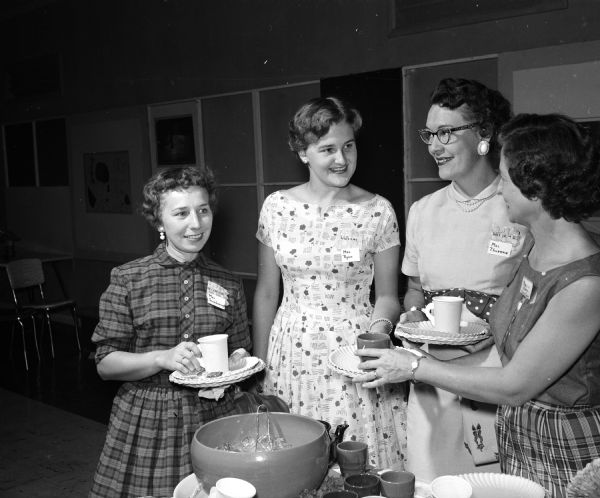 Truax Field Officers' Wives Club hosts a welcome party for newcomers. Attendees include, from left: Mrs. Harry Scarborough, Mary Ryan, Mrs. Wayne Thurman, and the club's hospitality chairman Mrs. William Eades.