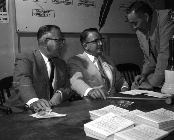 Three members of the United Givers' Fund campaign committee discuss plans. They include Theodore, M. Meloy, associate chairman of the campaign; Kenneth Sullivan and Philip J. Dickert, associate chairman.