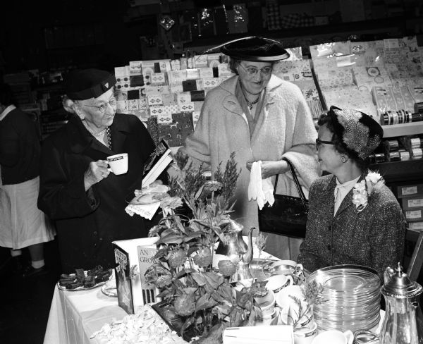 Three women are attending an autographing tea at Graham's Book and Stationary Store, 3238 University Avenue. They are, left to right: Helen Fairchild, Helen Conkle and Marie Steuber (wife of the author William F. Steuber).