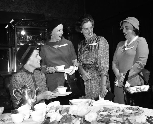 Miss Martha Peterson, dean of women at the University of Wisconsin, pouring at the AAUW tea. Three new members are standing next to her. They are Anne McTier, Marietta Fox, and Helen Dahm.