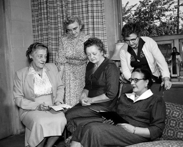 Members of the De Porres Guild make preparations for a benefit bazaar. Proceeds will go to the Blessed Martin Guild which funds social, recreational, cultural, and religious programs at Blessed Martin House. Discussing plans are, left to right, seated: Laura Ostrowky, Marcia Brossard, and Marcella Tomlinson, general chairman of the bazaar. Standing are: Mildred Downey, finance chairman and Margeurite Denton, president of the De Perres Guild.