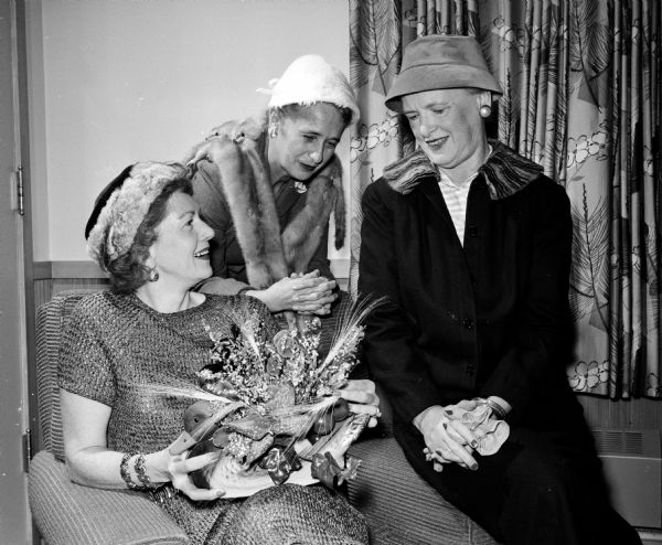 The Madison Visiting Nurse Service held its annual meeting at Blackhawk Country Club. The Visiting Nurse Service, a Red Feather agency, is the only service in Madison which furnishes bedside nursing care on a visit basis. From left to right are three members of the decorations committee: Jeanne Jackman, Lucille Clarke, and Alnora Lathers.