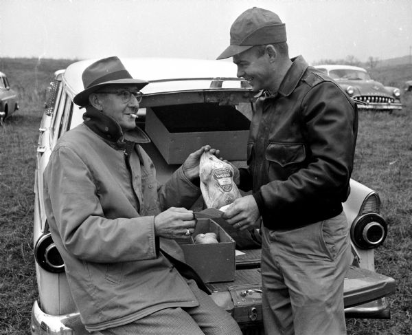 Ray Schmid (right) hands a frozen turkey to Ray Wolf, a winner of the Verona Optimist Club turkey shoot. Proceeds from the event go to the club's youth program.