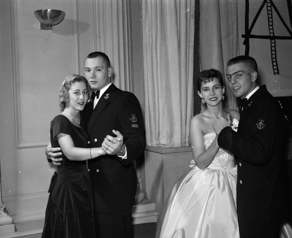 Two couples dance at the Navy Ball held for the Naval Reserve Officers Training Corps (NROTC) midshipmen at the Memorial Union's Great Hall. They are Sue Swanson and Sam Black, Rockford, Ill. (left), and Paulette Struck and Arnie Salvesen, Wausau (right).