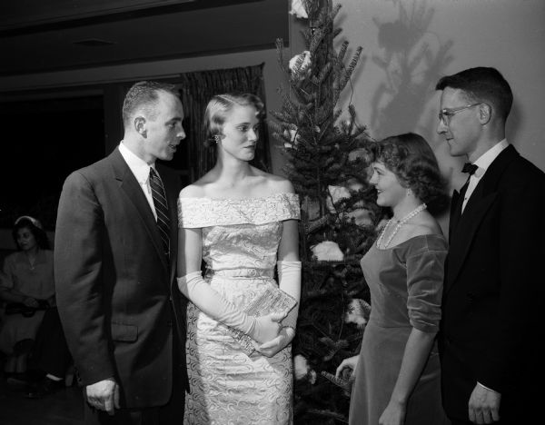 Group portrait of Dr. and Mrs. Harry Groth (left) and Dr. and Mrs. Robert Douglas. Mrs. Douglas was president of the Interns and Residents Wives' Club. A Christmas tree is in the background.