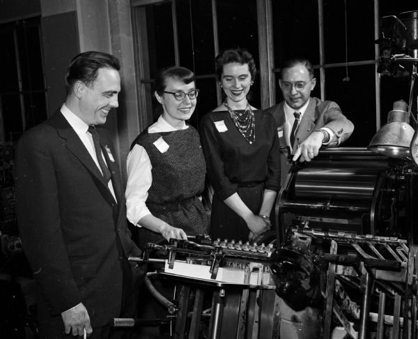 Jack Hutchinson (left), Patricia Stroud, Lynn Suhs, and Ward Cowles, head of the graphic arts department at the Vocational School, look at the school's printing equipment. The event is part of an observance of International Printing Week.