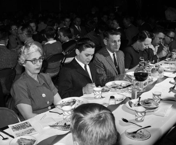 Annual meeting of the Madison Boy Scouts drum and bugle corps. Seated at the banquet table, left to right: Frances Stone, Ricky Stone, and Philip Stone.