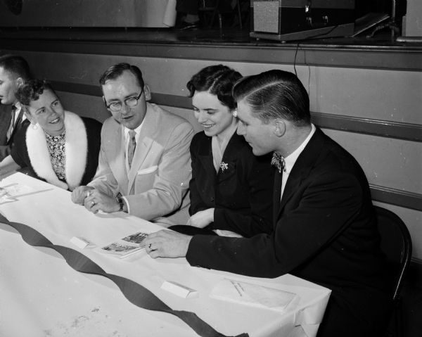 Boy Scout Drum and Bugle Corps leaders and their wives look over the souvenir program. Left to right: Celia and Henry Johnson; and Mr. & Mrs. Paul Haack.
