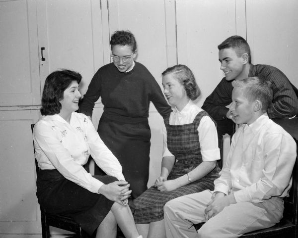 Wisconsin High School singers rehearse for a World Day of Prayer observance. Seated left to right are: Emine Ausar (an American Field Service student from Turkey), Nancy Munson, and Mary McAndrews. Standing is Bob Reznichek, and sitting is Bill Jacobs.