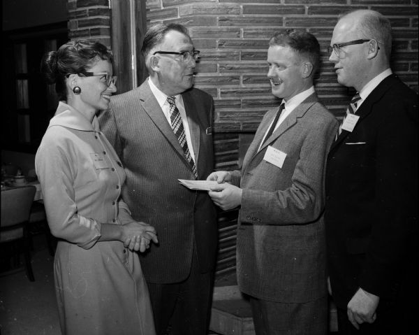 Marilyn Johnsrude and Everett Melvin receive second and first prizes for their advertising essays. The awards are presented by John Beyler, advertising manager of the Borden Co. and chairman of the National Advertising Week, and S. Watson Dunn, presedent of the M.A.C.