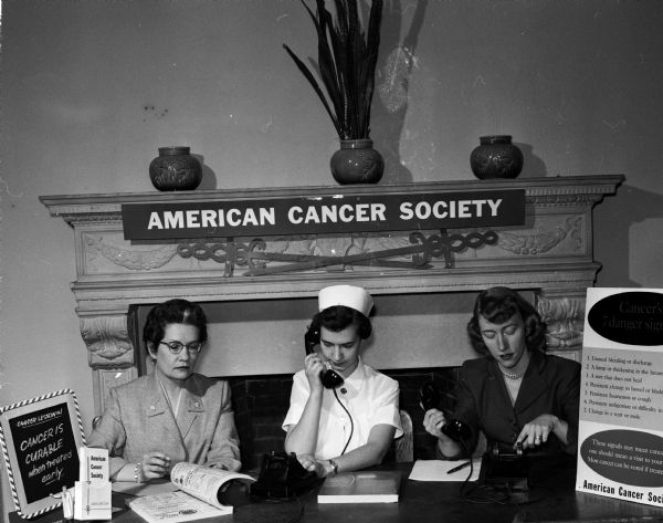 Members of the Dane County Medical Society, the Methodist Hospital Nurses' Alumnae Association, and the Dane County Unit of the American Cancer Society present an educational program about cancer. Questions submitted by the public will be answered by a panel of Madison doctors. Marjorie Seybold (left), Carolyn Fillner, and Marlene Treadaway, all graduate nurses, work on the telephone survey to obtain the questions for the panel.