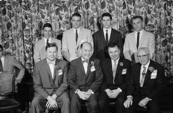 Group portrait of Wisconsin boxers who have received awards and some of the speakers at the John Walsh testimonial dinner marking his retirement. Front row: Truman Torgerson, Coach John Walsh, Warren Jollymore, and George Barton. Back row: Rollie Nesbit, Bob Christopherson, Charles Mohr and Al Schmolze.