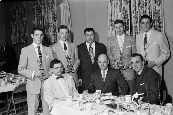 Group portrait of the principal participants in Oregon High School's annual athletic banquet. Shown seated left to right: Rev. Robert Conner toastmaster; Jerry Thompson, main speaker; basketball coach Elmer Duerst.  Standing:  Clark Dupont; Mel Gard; football coach Erwin Kissling; Terry Inslee; and Ken Orvold.
