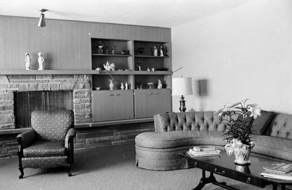 The living room of the E.H. Karsten house at 2918 Waunona Way is done in shades of beige; a sectional sofa is a warm sand tone and furniture finishes are dark wood. One long window overlooks Lake Monona.