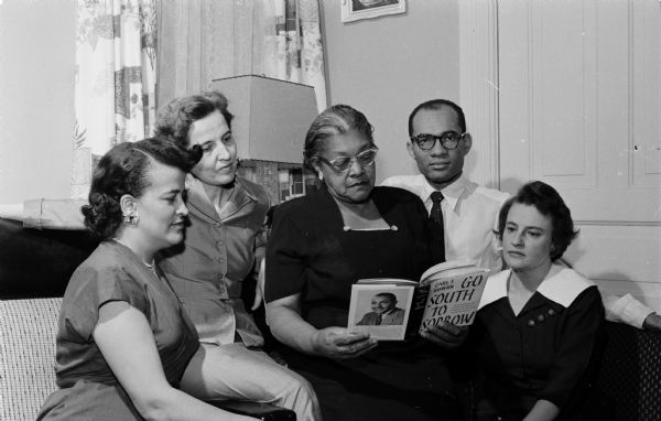 Five people admire a book entitled "Go South To Sorrow" which will be given as a prize for the NAACP's Madison branch membership drive at the annual freedom fund dinner. They are (L-R): Mabel Styles, Gretchen Pfankuchen, Eunice Guy, Lloyd Barbee, and Bettylu Anderson. The book's author, "Carl T. Rowan, reporter for the 'Minneapolis Tribune,'" spoke at the dinner.