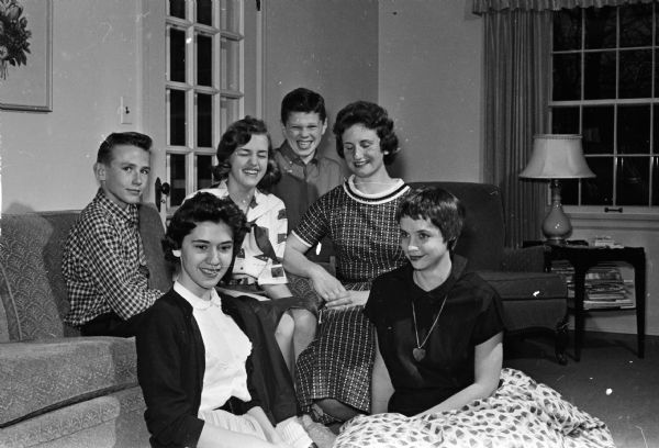 Teen-aged members of a planning committee for a dance sponsored by the Sunset Village Community Club are gathered around a couch. Seated on the floor are Sandra Brown, left, and Cheryl Brickl. Others are (left to right), Al Durand, Janis Wilson, Ron Fagerstrom, and Barbara Palm.