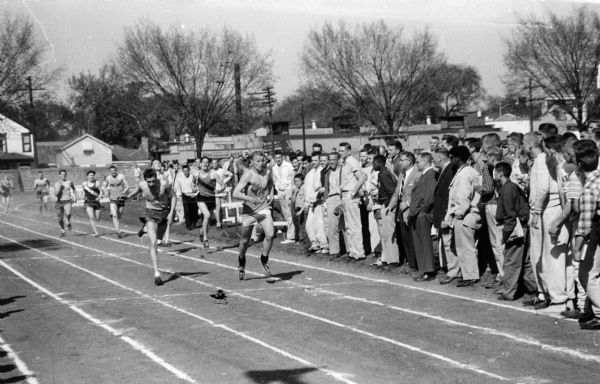 Action shot of the finish of the 440 yard dash, showing Fred Lichte, East High School, finishing second; Vito Gervasi, of Central High School, center, placing third; and Mike Morgan of West High School, winning first place.