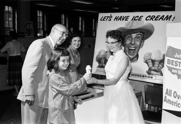 Security State Bank presented children with ice cream cones in recognition of June Dairy Month. Leo Lunenschloss, bank president, is looking on as Sarah Hole accepts an ice cream cone from Darlene Kripps. Margie Hags is in the background.