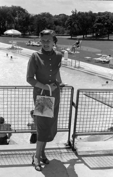 Portrait of Elsa Johnson on the Maple Bluff Country Club porch overlooking the swimming pool. All activities of the Maple Bluff Country Club Women's Group are under her direction. She is the mother of three teen-age sons and a younger daughter.