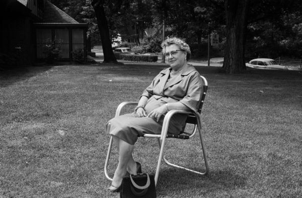 Portrait of Hella Johnson sitting in front of the Nakoma Country Club clubhouse. She serves as president of the Woman's Organization of the Nakoma Country Club. She is a grandmother of nine and and avid golfer and bridge player.