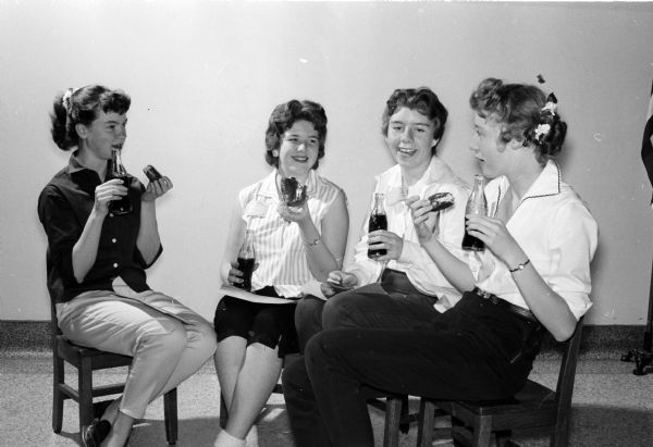 Elaine Schluter (left), Judy Beyers, Pat Whitney, and Dolores Reimer enjoying soft drinks and doughnuts at the 'get-acquainted' party.