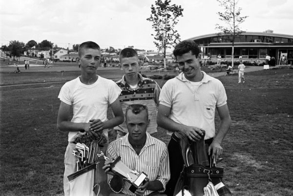 Ray Hustad, sitting, displays his championship trophy won in the JCC junior golf tournament as Madison's three other qualifiers to the state meet look on. They are, left to right: Ralph (Butch) Schlicht, Kully Schlicht Jr. and Dick Quintana. The tournament was played at the West Side Park.