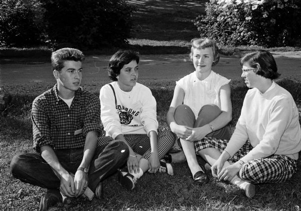 Group portrait of American Field Service students on their way back to their native countries after having spent the past year in the area. They were entertained and housed for three days by the members of the East Side Youth Mayor's Council. Shown at a picnic in Vilas Park are Giovanni Belgiojoso, Italy, who has been living in Mankato, Minnesota; Leonor Perez-Pita, Spain, Cedarburg; Jaaike Van Der Velde, Holland, Winona, Minnesota; and Karen Isaksen, 6219 Countryside Lane, who spent last summer in Holland as an AFS student.