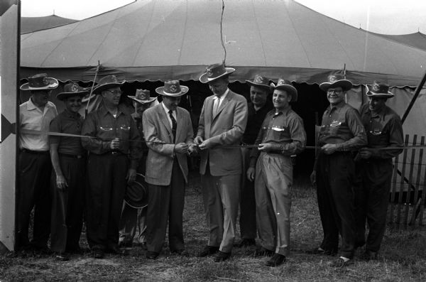 Madison Mayor Ivan Nestingen, second from right, poses with scissors while opening the 36th Annual East Side Business Men's Festival, held at Voit Field. Standing with him from left to right are: Marshall Browne, Ernest Farrow, Alfred Ellickson, Al McGinnis, Leon Kronenberg, and William Sandberg.