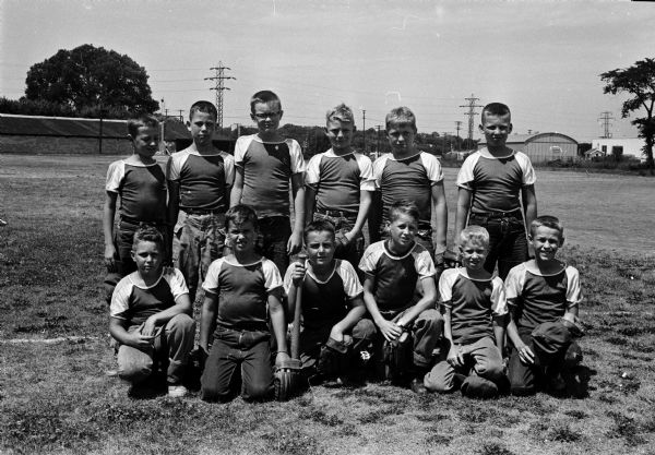 Group portrait of the Kupfer Foundry team, winners of the East Midget Burr Jones baseball league. Front row, left to right: Paul Holtzman, Jim PiPiazza, Frank Allen, Steve O'Kane, Peter Holtzman, George Blodgett. Back row: Roger Cole, Ricky Moe, George Oliver, Steve Ashmore, Ken Krall, and Gary Schultis.