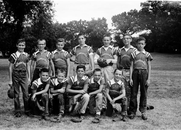 Group portrait of the Shamrocks midget baseball team after winning its first playoff game in the West Midget Wingra playoffs. Left to right, front row: Ted Balistreri, Tony Tormey, Rod Lombardo, Tim Sweeney, Greg Sweeney. Back row: Jim Pfeifer, Greg Zweitler, Dave Scoon, John Renk, Dennis Sweeney, John Helm, Bill Sweeney.