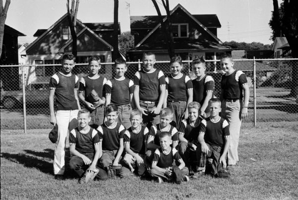 Group portrait of Thaller's Steak House team, East Midget Central No. 2 champions. Having been unbeaten in 18 games, they lost to Gallagher's in the title game. Left to right: Front - Batboy Charles Brys. Kneeling - Robert Stevens, Tom Dell, Richard Jaronby, Darrell Hanson, Bill Starr, Mike Hall. Standing - Sheldon Sabinson, Bob Bosold, Chuck Wilcox, Vernon Geishert, Dennis Swingle, Jerry Prideaux, Bob Bernhagen.