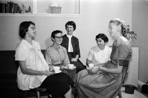 New women faculty members and wives of new University of Wisconsin faculty members are guests of honor at informal, get-acquainted coffee parties planned by the Junior division of the University League. Attending one of the parties are (left to right) Mrs. D.L. Leussing, Mrs. William Moy, Mrs. T.W. Tibbitts, Mrs. Roger Miller, and Mrs. Donald Osterbrock.