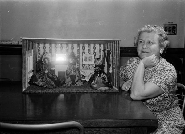 Doris Withrow bids farewell to the dolls which she has dressed for her entry in this year's National Doll Dressing Institute competition held in cooperation with the New York March of Dimes. Miss Withrow won first prize for Wisconsin in last year's competition.